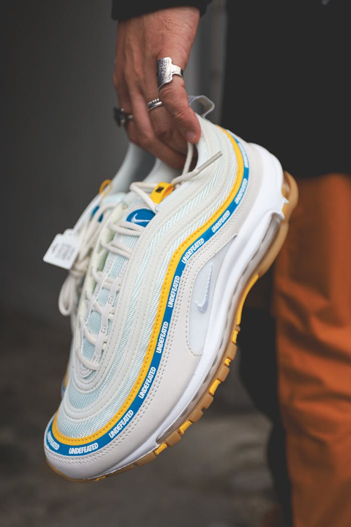 Close-up of a person holding a trendy Nike sneaker, perfect for fashion enthusiasts.