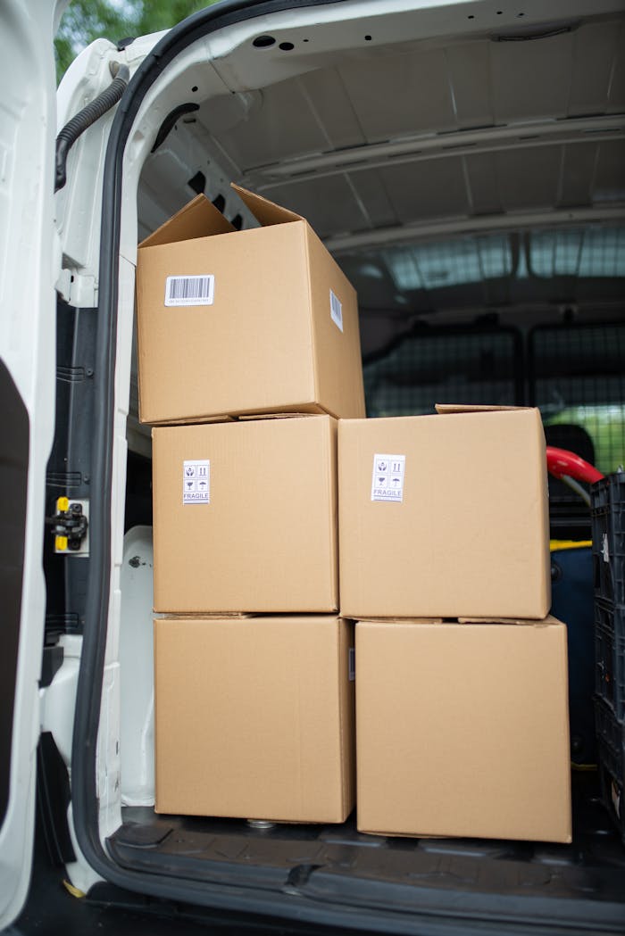 Home Stacked cardboard boxes inside an open delivery van, ready for shipment.